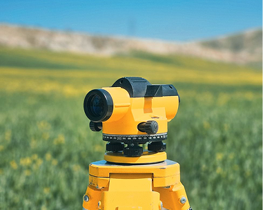 Surveying level on a tripod in open land